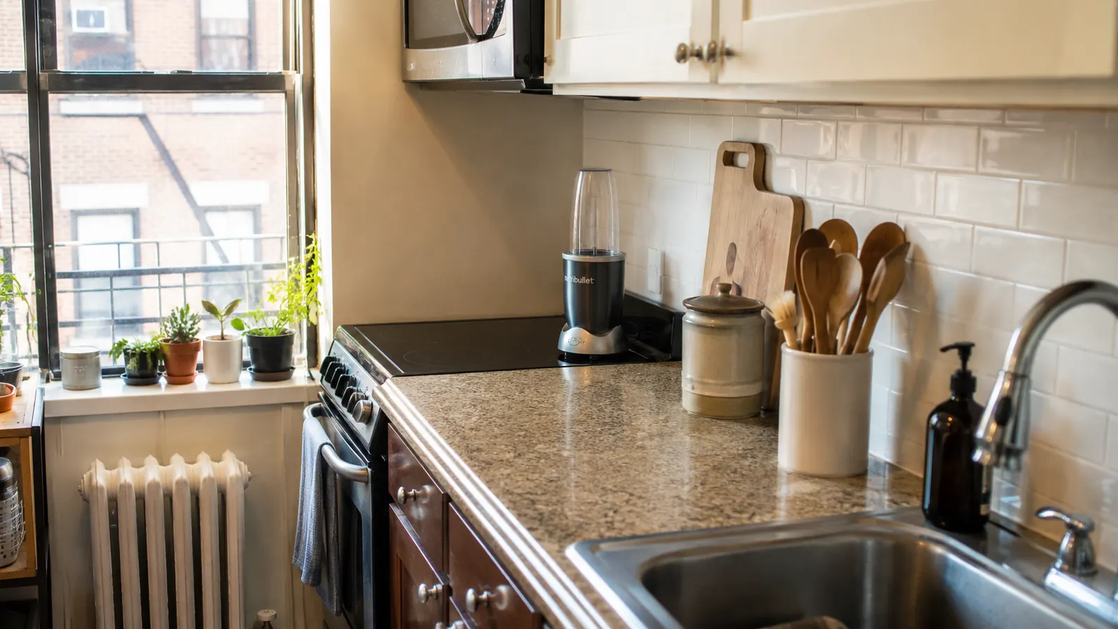 A small kitchen counter with the personal blender tucked into a back corner, showing the open space it leaves behind